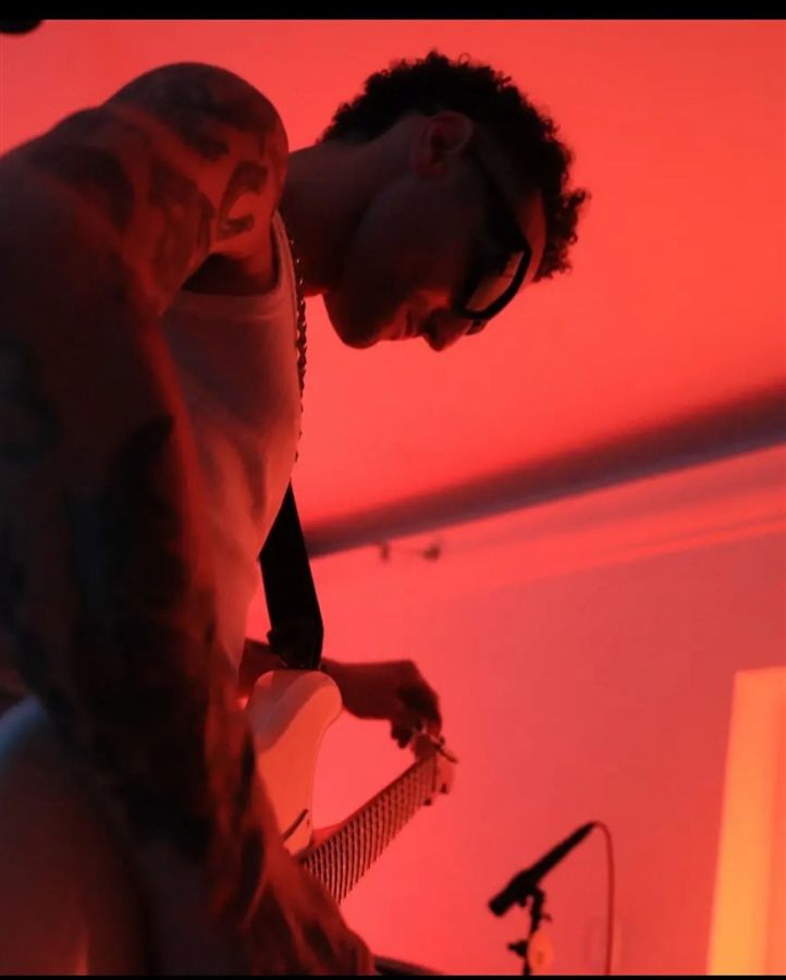 Pablo Malvin tocando la guitarra en vivo, luces rojas