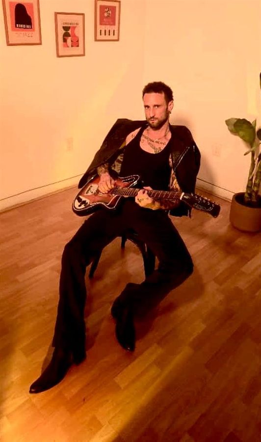 Pablo Malvin tocando la guitarra en un estudio casero