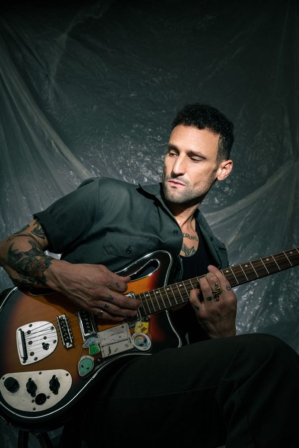 Retrato de Pablo Malvin tocando la guitarra, luz dramática